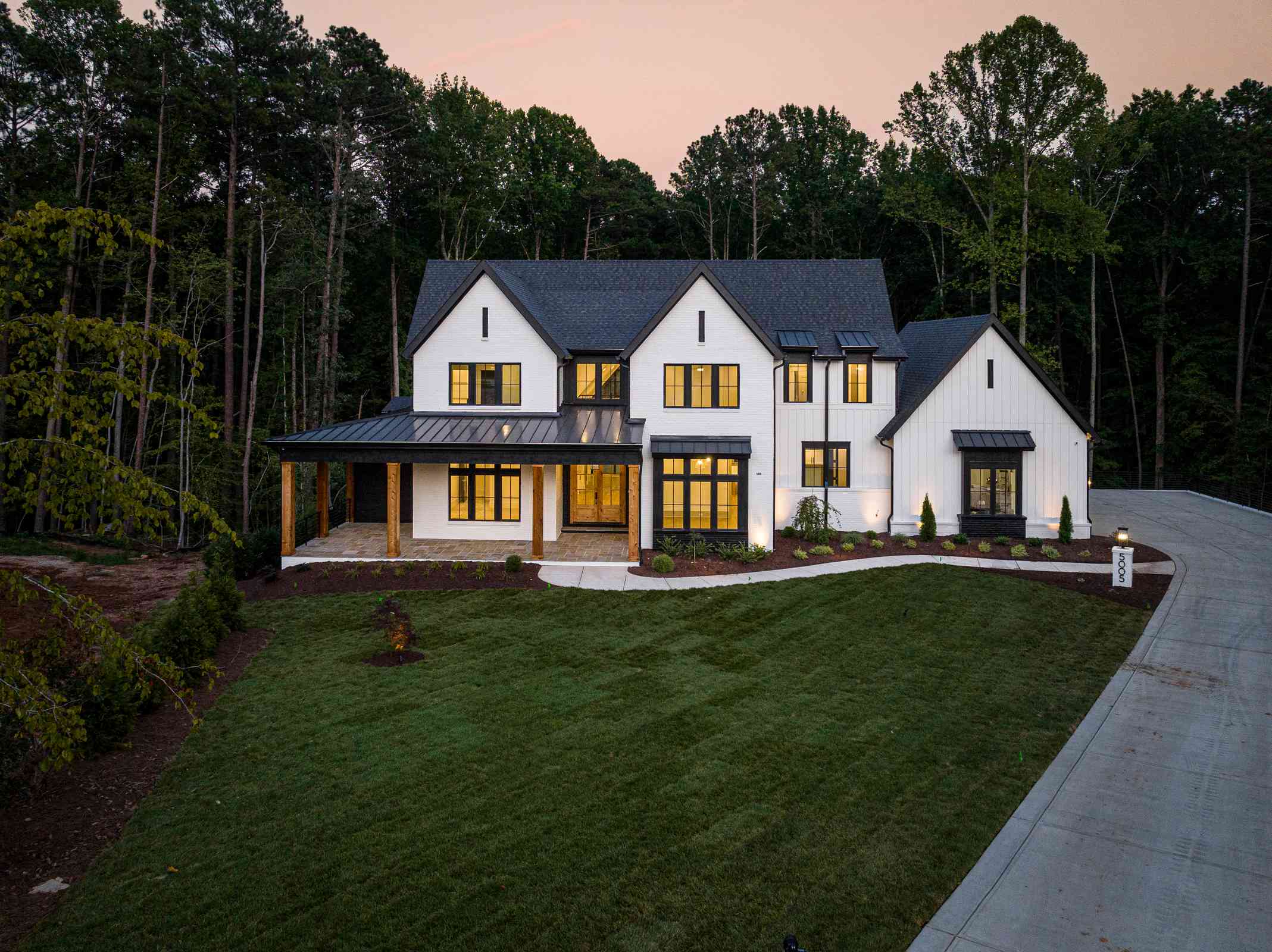 Evening drone view with property lighting by Shail Construction in Chapel Hill NC
