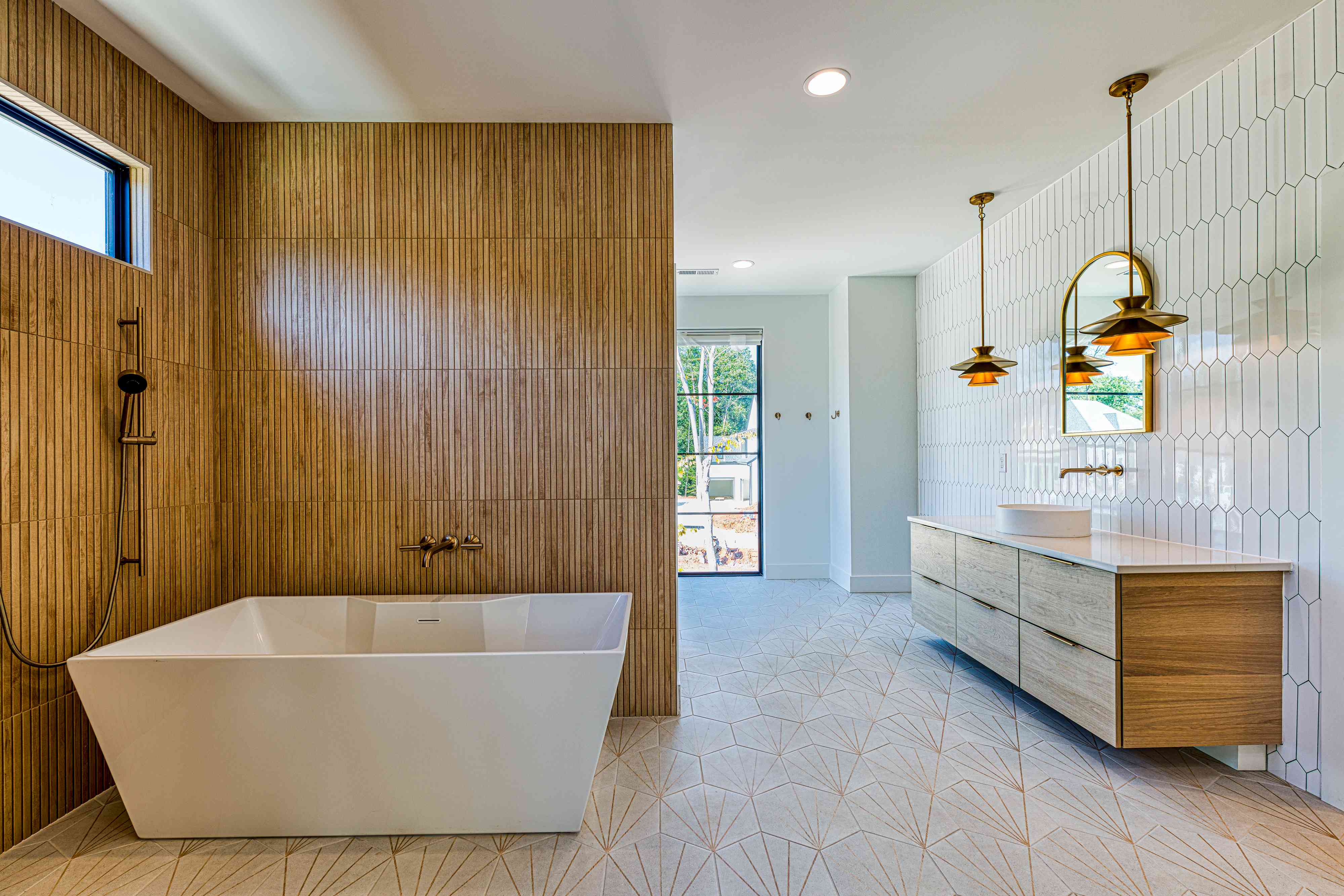 Renovated primary bathroom with marble and brass by Shail Construction in Raleigh NC