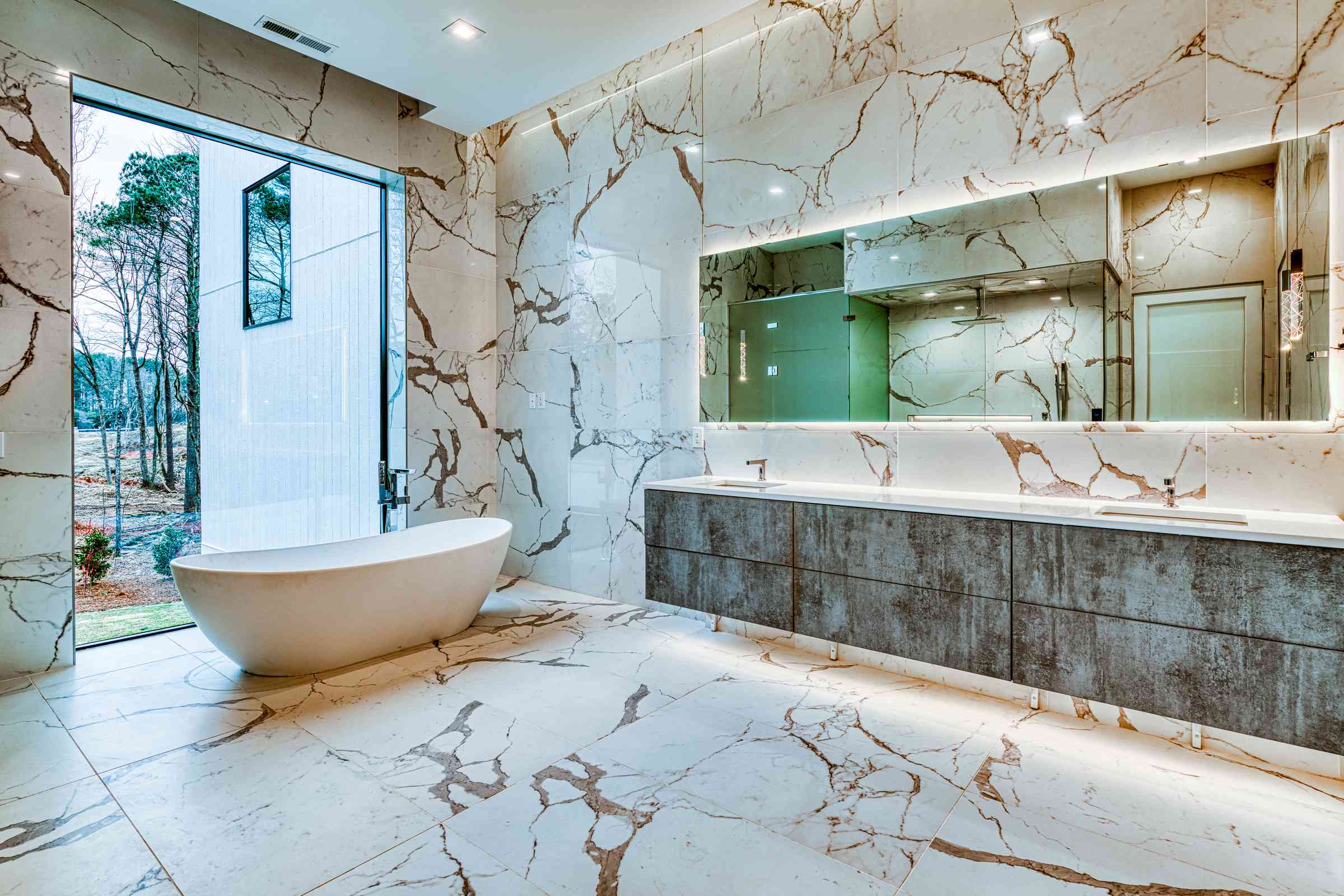 Lower-level primary bathroom with calacatta marble by Shail Construction in Chapel Hill NC