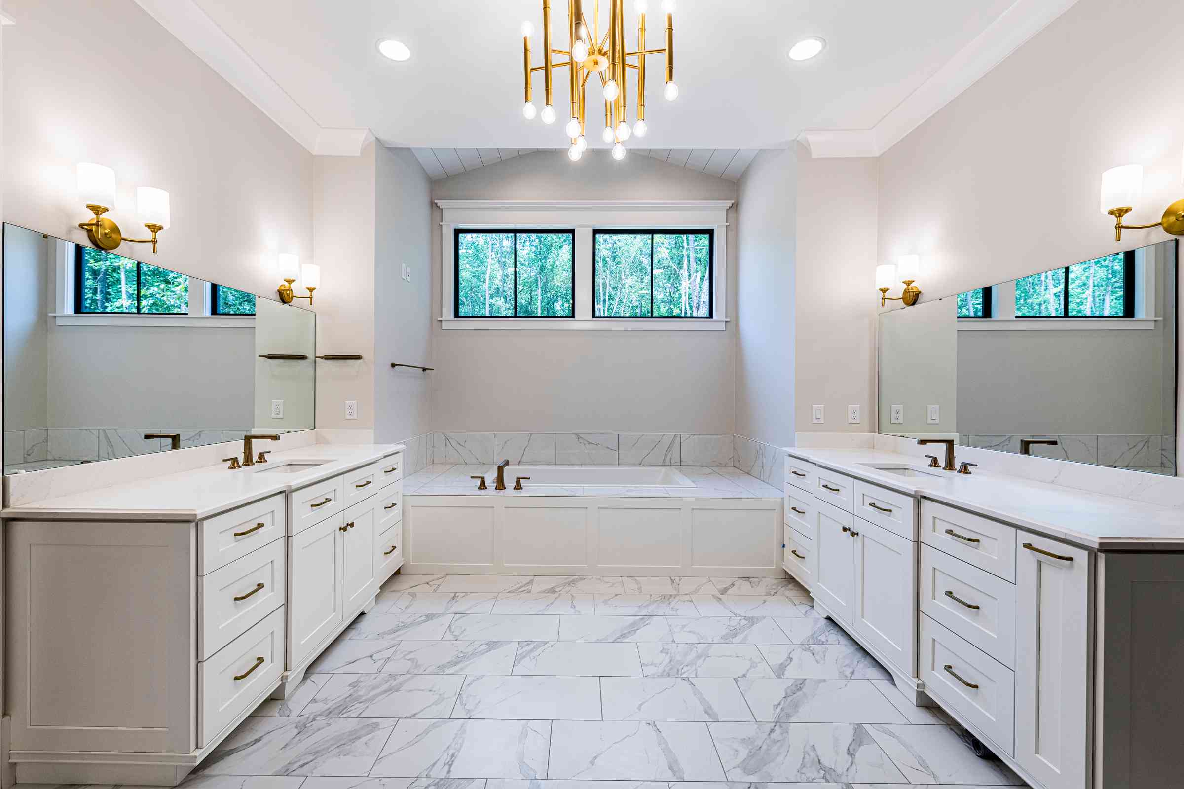 Spa-style primary bathroom with marble and stone walls by Shail Construction in Chapel Hill NC