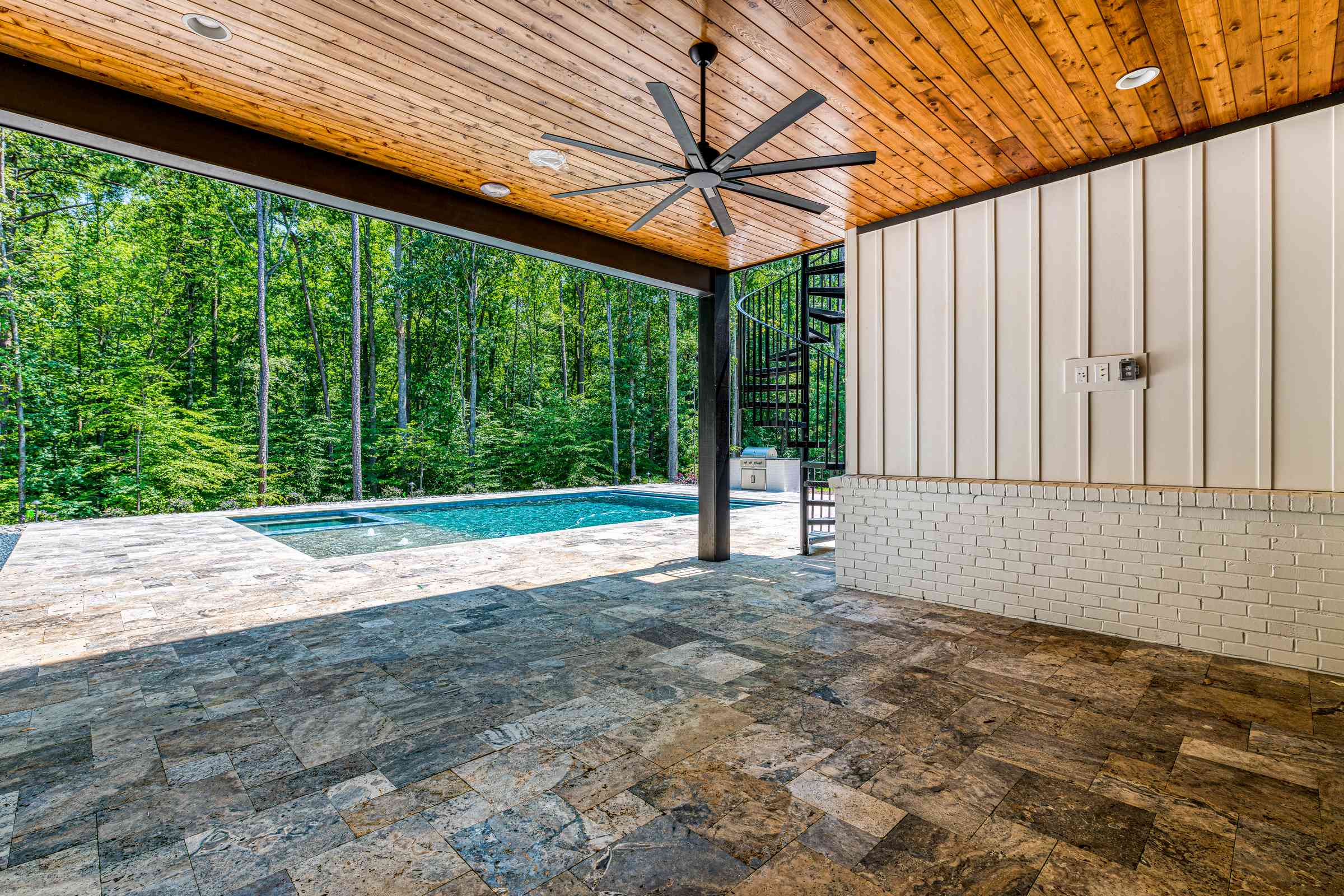 Covered outdoor patio with stone fireplace by Shail Construction in Raleigh NC