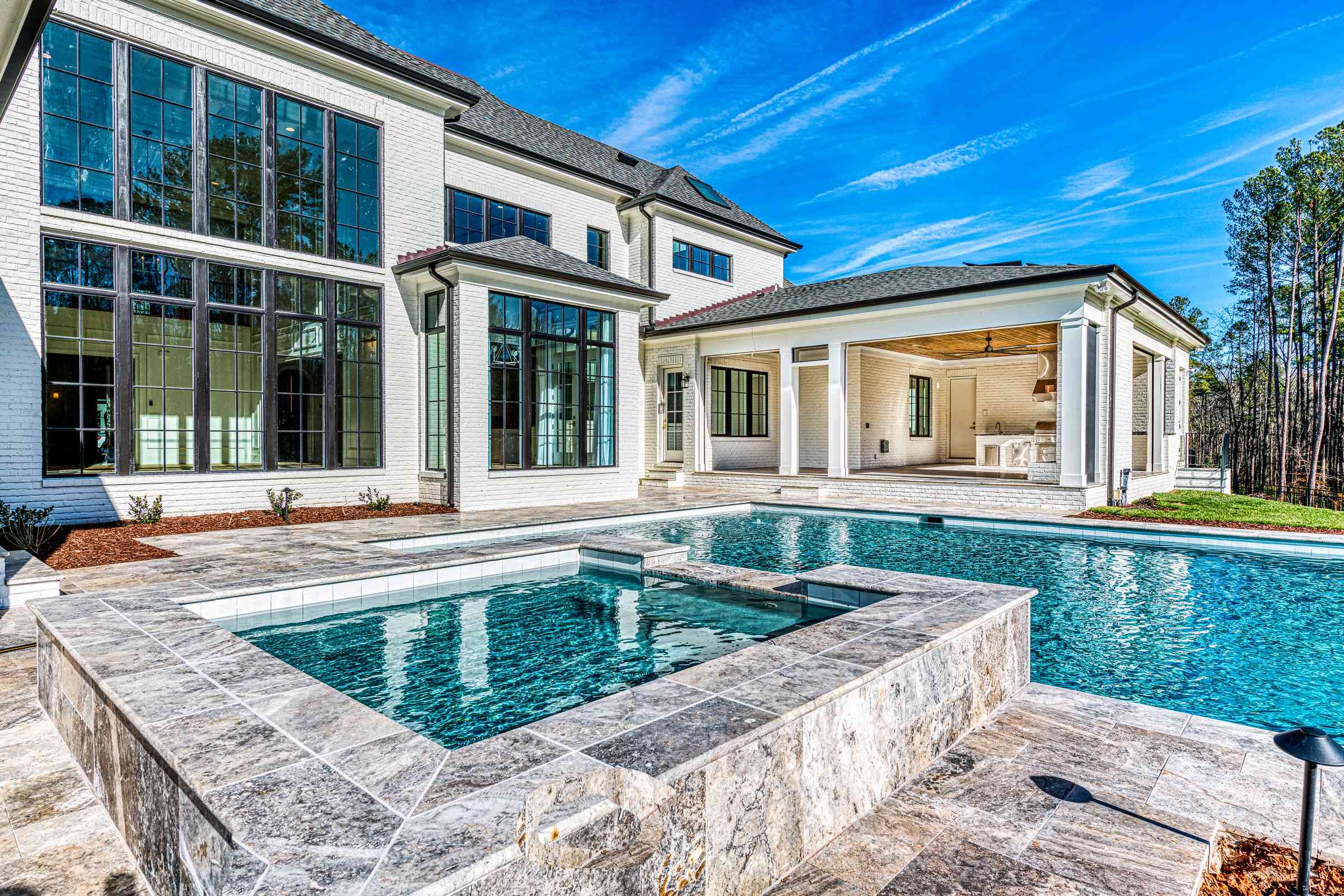Pool with raised spa and waterfall feature by Shail Construction in Raleigh NC