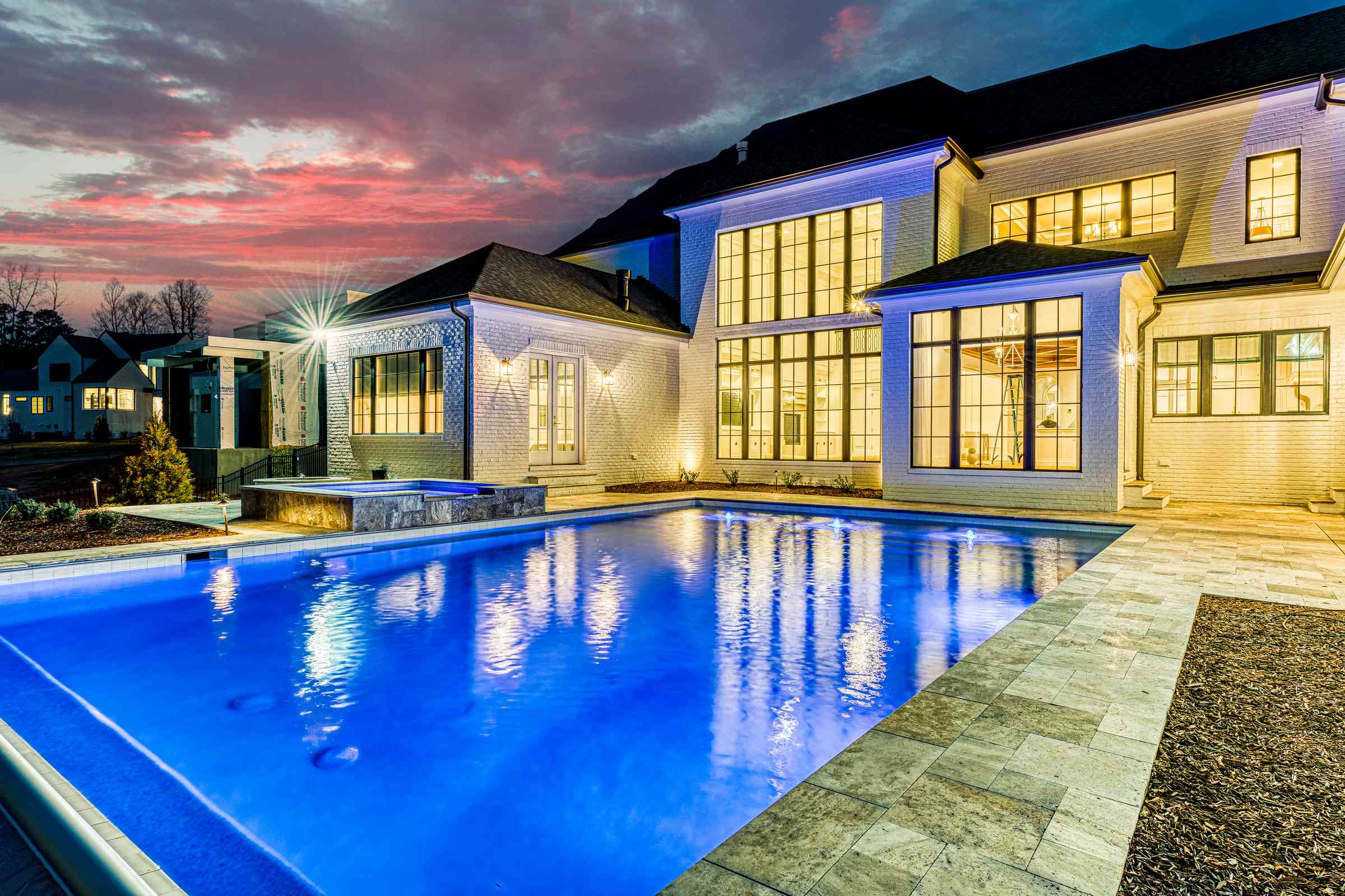 Twilight pool view with house in background by Shail Construction in Raleigh NC