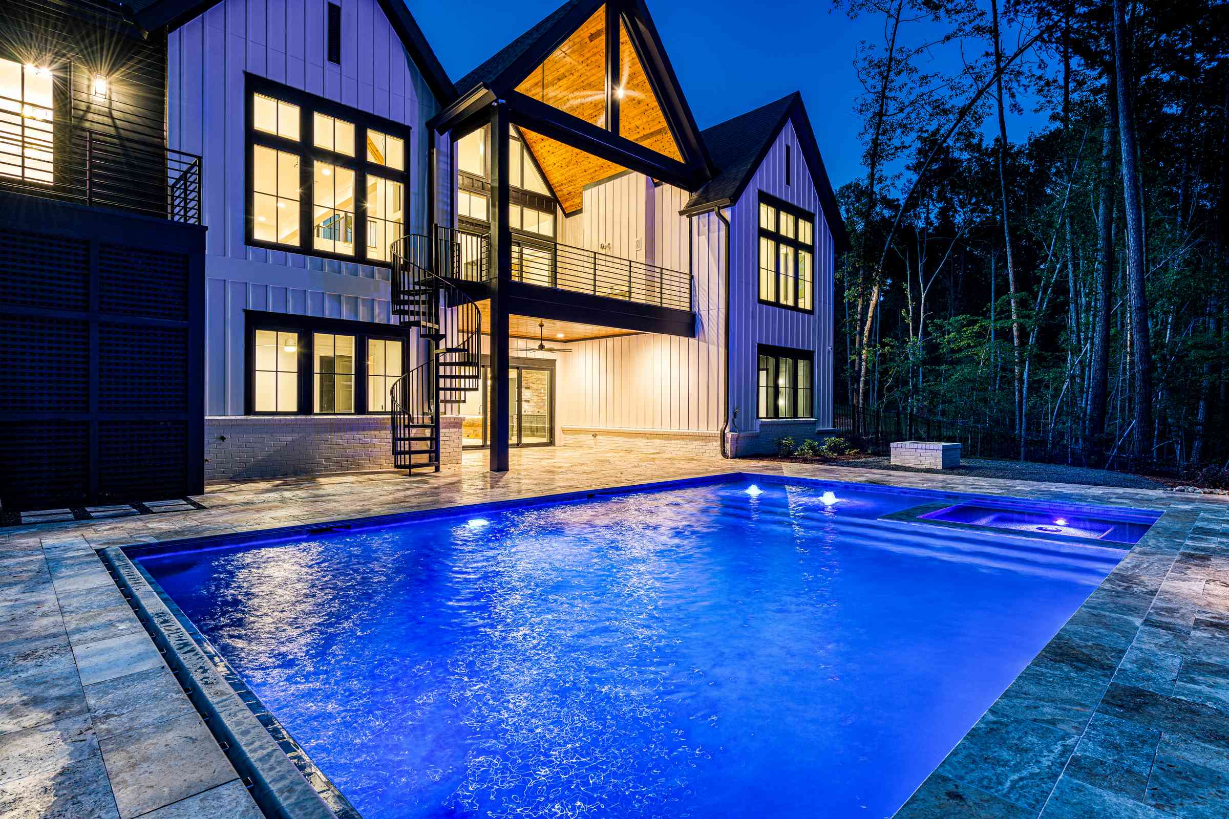 Rear of estate at dusk with covered porch lit by Shail Construction in Chapel Hill NC