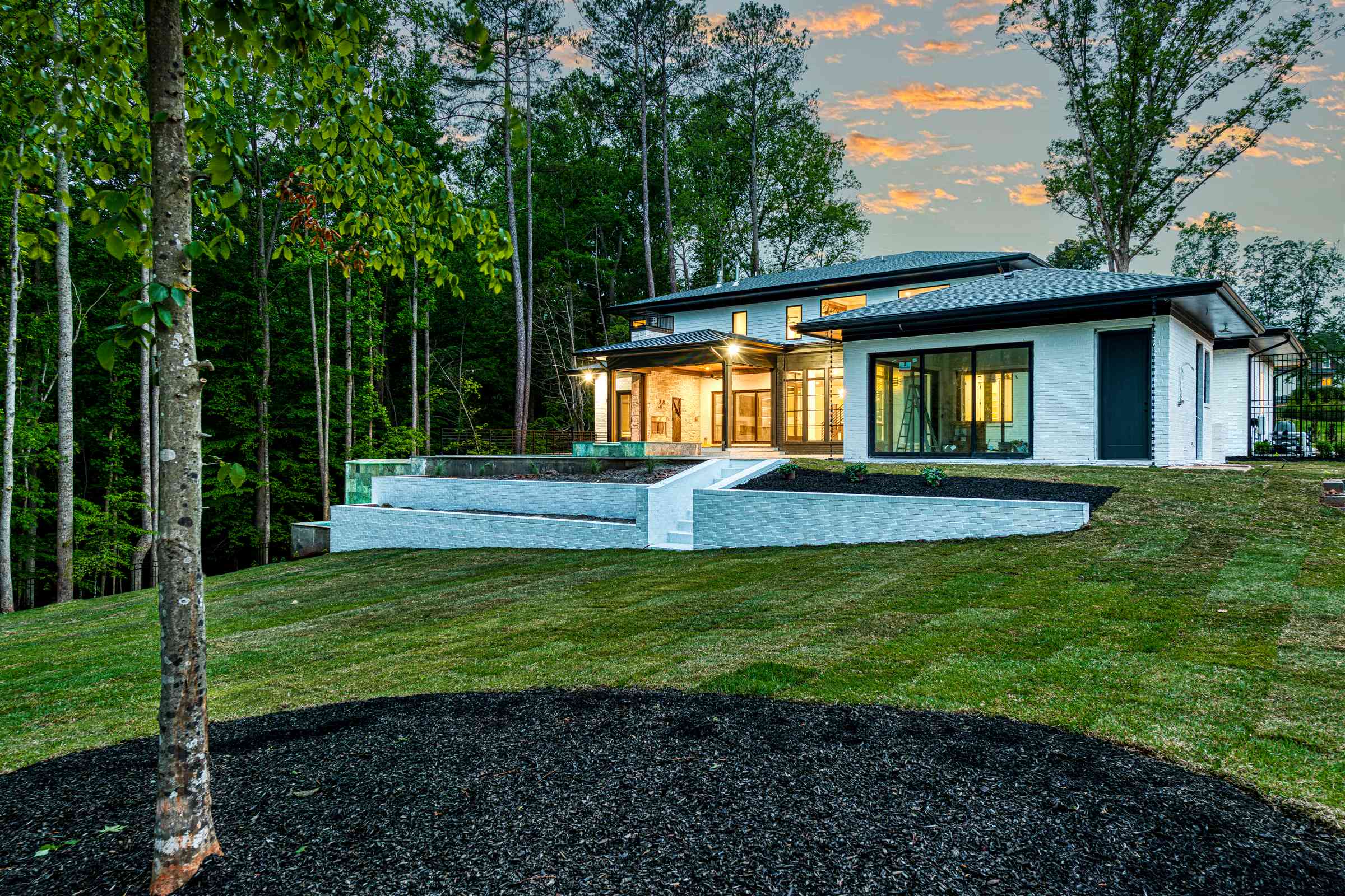 Twilight rear elevation with terrace lighting by Shail Construction in Durham NC