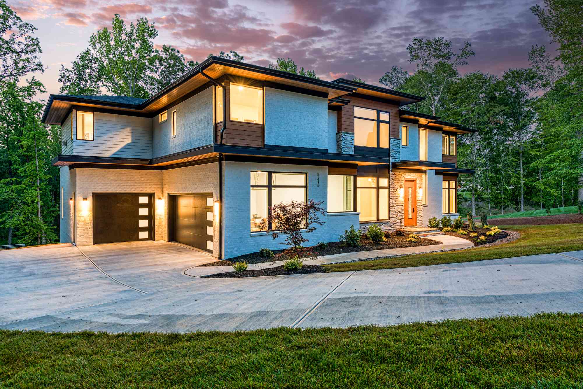 Evening front exterior with landscape uplighting by Shail Construction in Wake Forest NC